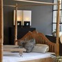 Besonderes Himmelbett aus Plantagen Teakholz im Kolonialstil, ein Massivholz Moebel vom Schreinermeister in Handarbeit gefertigt, schicke Kissen und ein Massivholz Tablett als Accessoires zur Dekoration, Moebel Muenchen Teak Massivholz