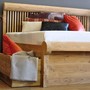 Bett mit Bettkasten aus  Plantagen Teakholz, Massivholz Teak Bett Giovanni in der Holz Farbe Roh aus der MOEBEL KOLONIE Farbpalette, Kissen und Plaid als Accessoires für das Edelholz Bett aus Teak, Moebel Muenchen