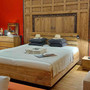 Elegantes Bett Wunder aus Massivholz Teak mit Bettkasten und Stauraum, Dekoration ist ein antikes Teakholz Tor, edles bicolor Massivholzbett im modernen Design in der MOEBEL KOLONIE Manufaktur vom Schreiner in Handarbeit gefertigt, unser Schreiner zimmert auch individuell nach Mass fuer Ihr Schlafzimmer, das Kopfteil hat Streben aus Metall, Moebel Muenchen Teak Massivholz